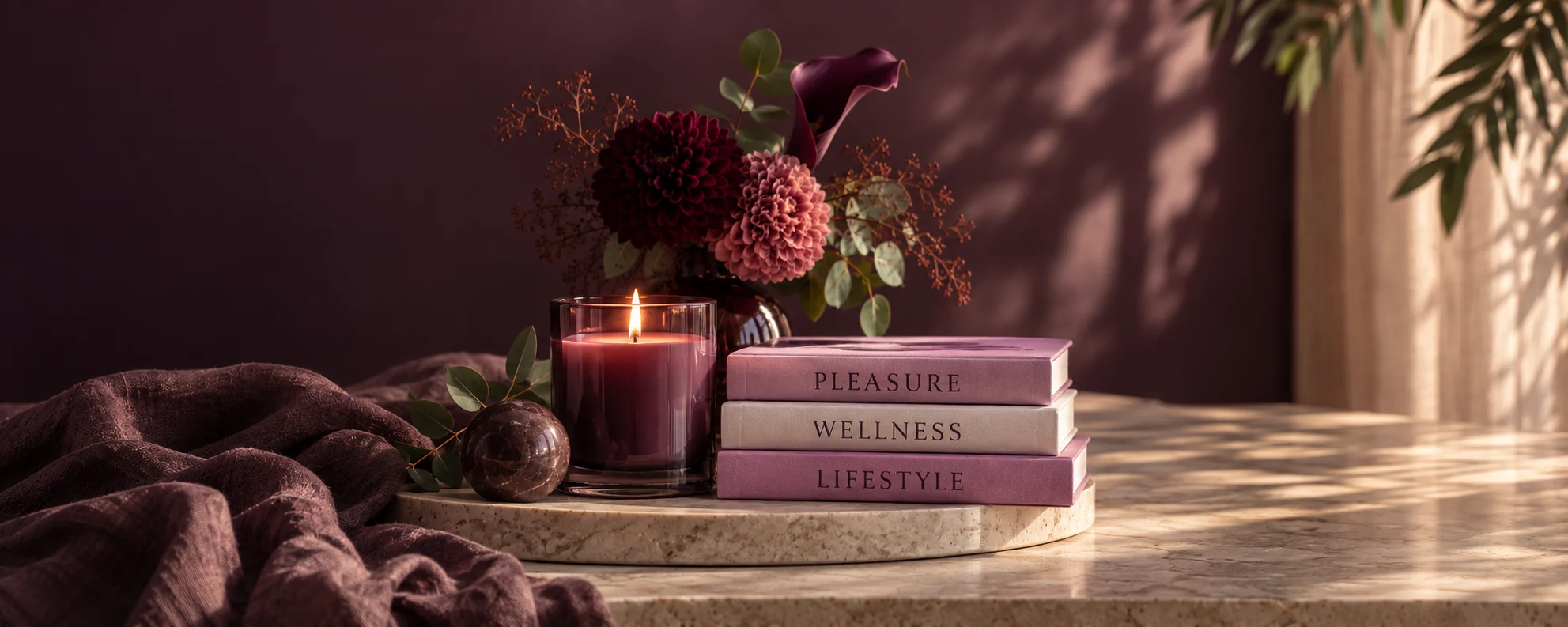 Pleasure, Wellness and Lifestyle books beside a glowing candle